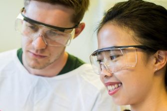 Students in lab looking at tissue culture tube