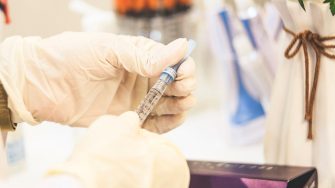 Person holding syringe in science lab