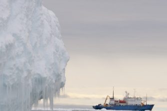 Iceberg in foreground with ship in background