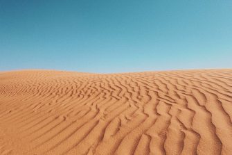 Red sand dunes under a clear blue sky