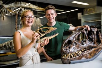 Photograph of a group of science students examinig some dinosaur bones