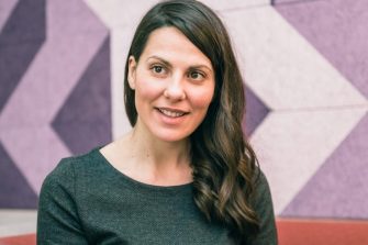 Dark haired woman sitting on a bench