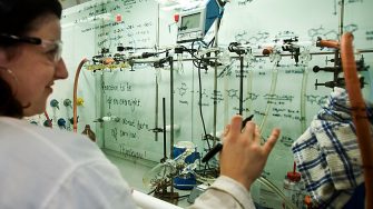 Scientist writing on fumehood