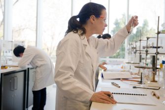 Student looking at a test tube in the lab