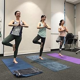 3 students doing yoga tree pose