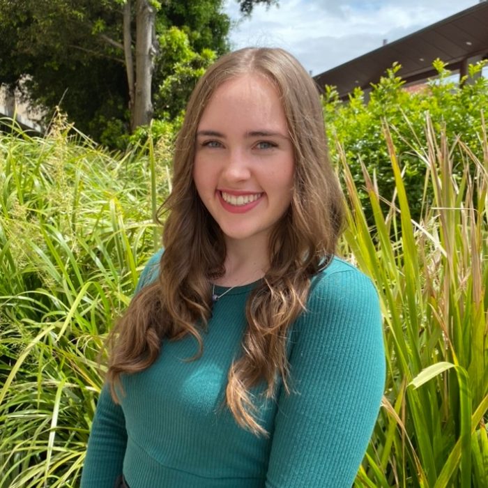 A picture of a girl in front of tall grass