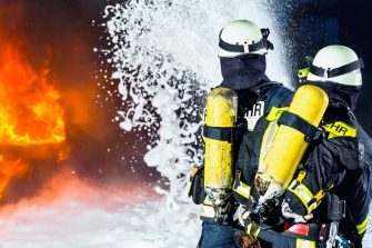 Firefighter spraying firefighting foam at a training facility