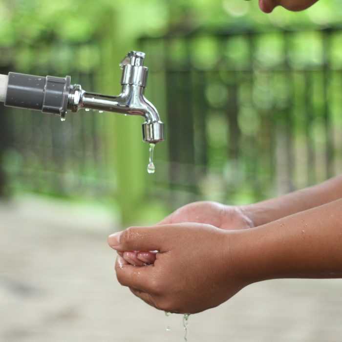 Person washing their hands at a tap
