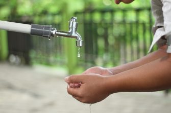 Hands catching water from a dripping tap