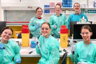 A group photo of SciX students in a lab on campus