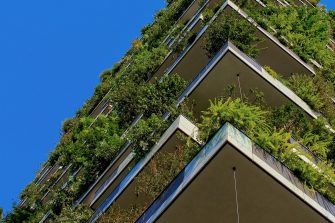 low angle of tall building with plants and blue sky