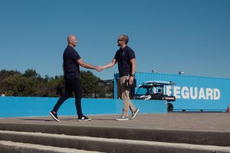 Two males shaking hands outdoors