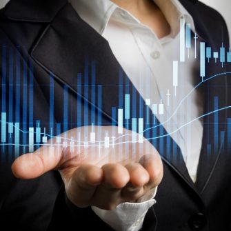 Wusiness woman in black suit with open palm hand showing stock graph