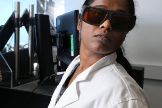 A lab technician working with physics equipment