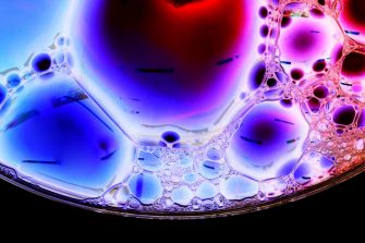 Micro Bubbles Cluster backlit with a white light. Micro Bubbles infrared a Pink and Purple liquid. Close up taken with a Macro lens in the studio.