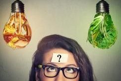 A woman considers two seperate lightbulbs representing healthy and unhealthy choices