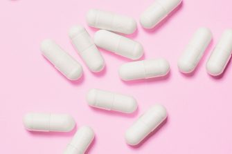 White pills on pink background