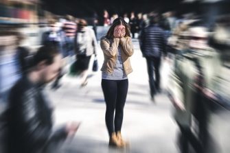 Woman standing in crowd covering eyes