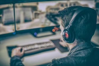 Young man wearing headphone playing computer games