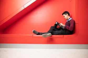 Student reading in big red seat