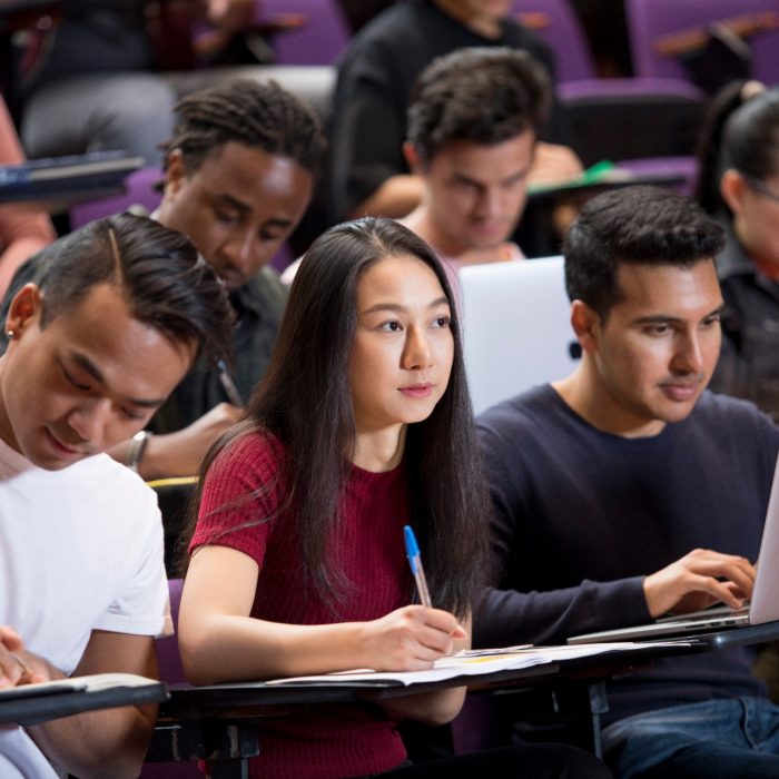 Students with laptops in lecture theatre class