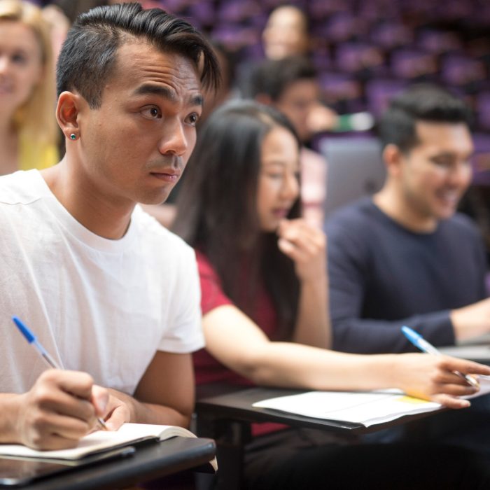 Students with laptops in lecture theatre class
