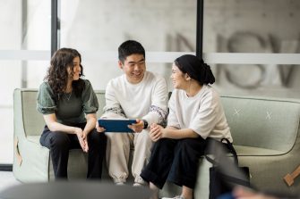 Students sitting and smiling in the Student Hub at L5