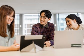 Three students studying with laptops