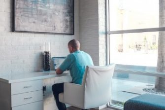 Male UNSW student making a report on a laptop