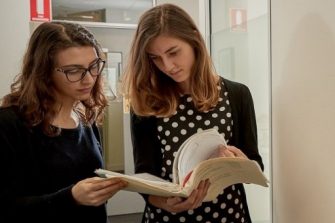 Photo of two peoplle examining documents together