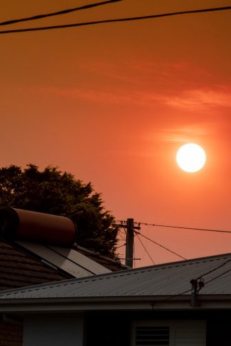 Australian bushfire: smoke from bushfires covers the sky and yellow and red sunset above the roofs looks frightening. Suburb in a smoke haze. Catastrophic fire danger, NSW, Australia