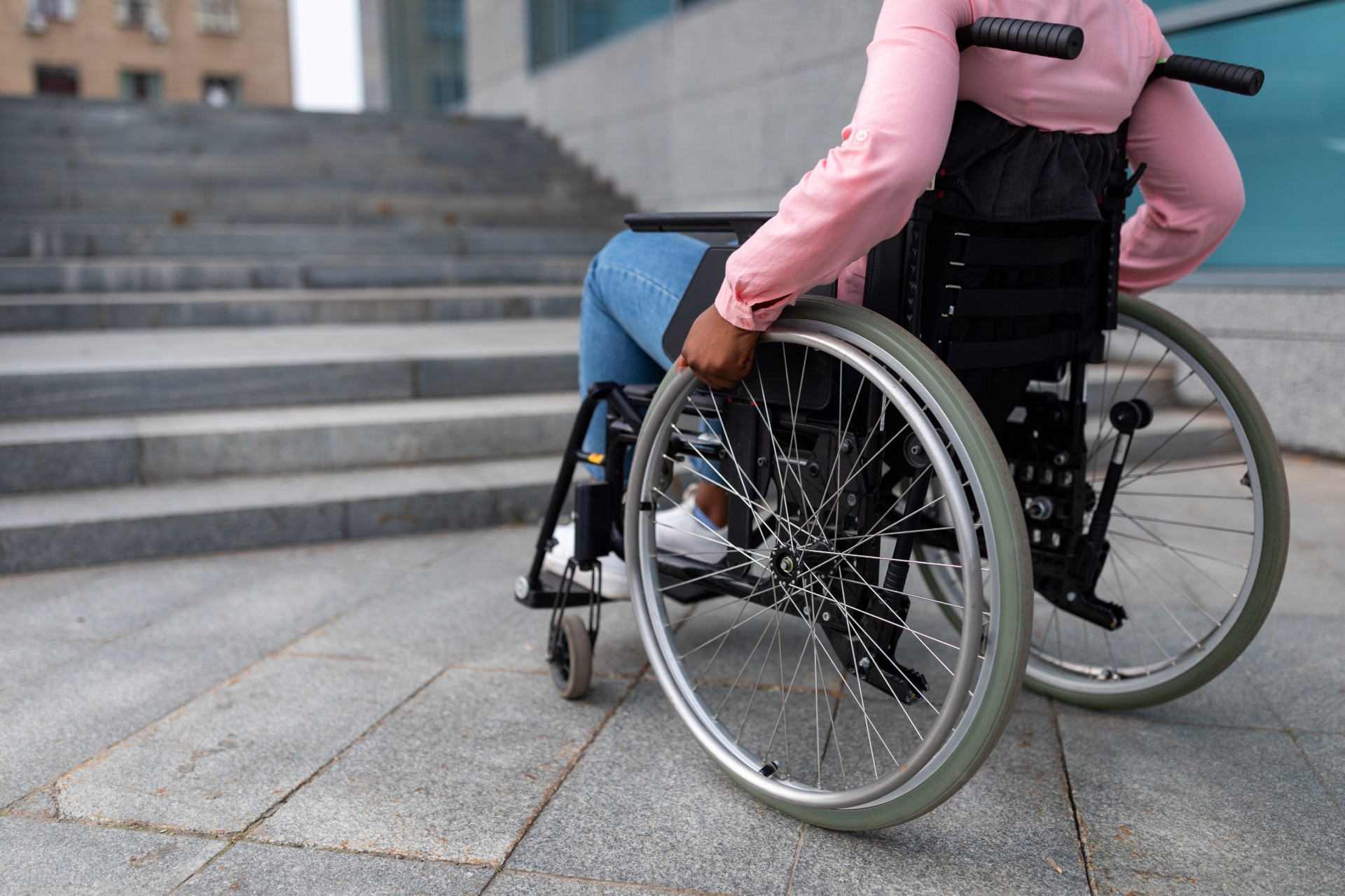 Person in wheelchair facing a staircase