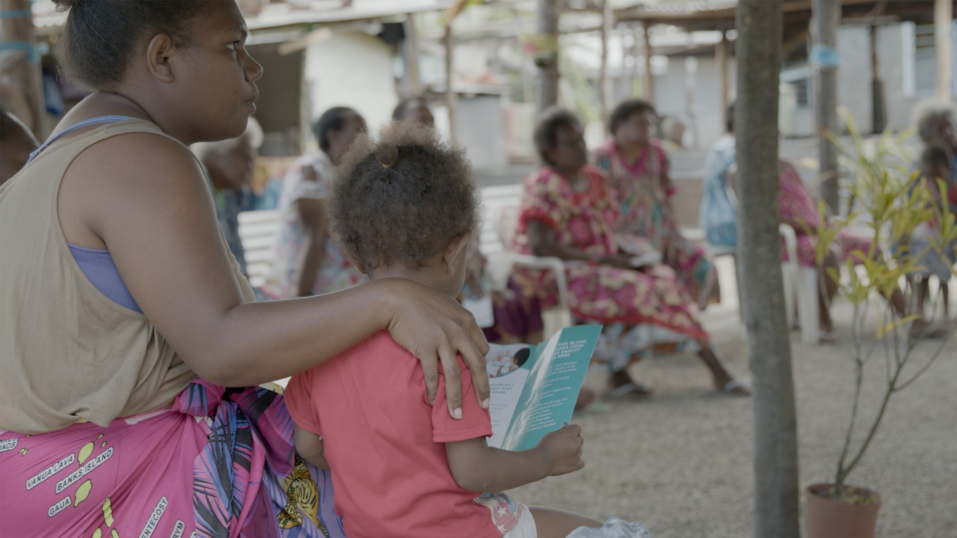 A woman with a child looking at someone speak