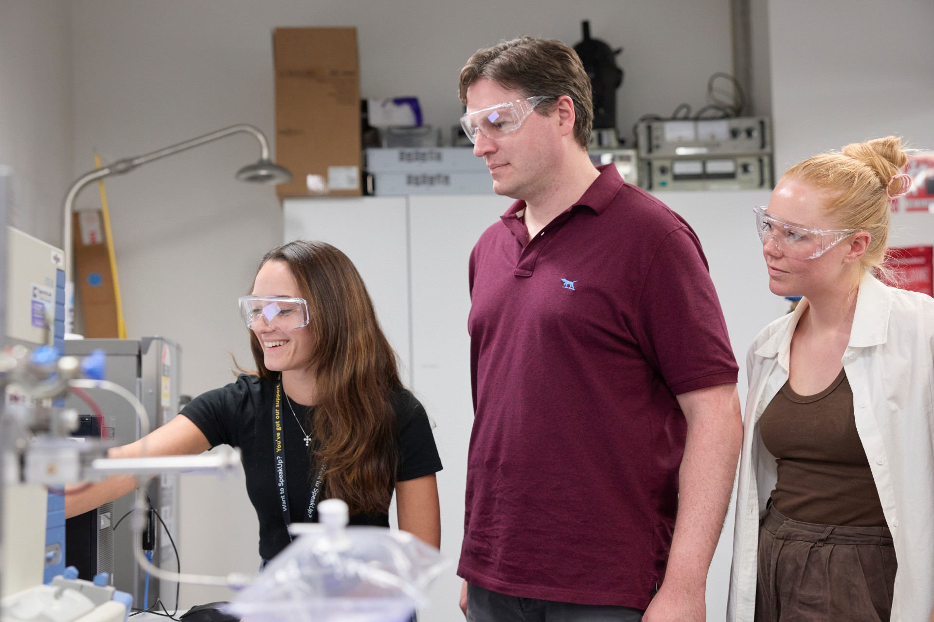 Laura Capasso, William Alexander Donald and Merryn Baker looking at equipment that analyses breath samples for early detection of silicosis in a lab in School of Chemistry