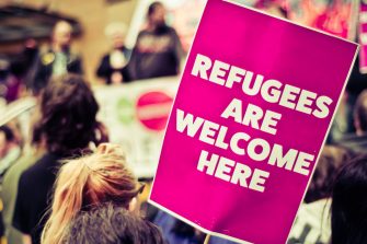 Busy Street Protest March With A Sign Saying Refugees Are Welcome Heren