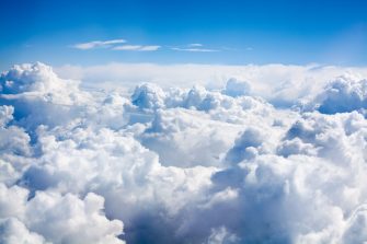 White clouds on blue sky background close up, cumulus clouds high in azure skies, beautiful aerial cloudscape view from above, sunny heaven landscape, bright cloudy sky view from airplane, copy space
