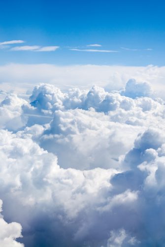 White clouds on blue sky background close up, cumulus clouds high in azure skies, beautiful aerial cloudscape view from above, sunny heaven landscape, bright cloudy sky view from airplane, copy space