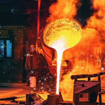 Liquid iron molten metal pouring in container, industrial metallurgical factory, foundry cast, heavy industry background.