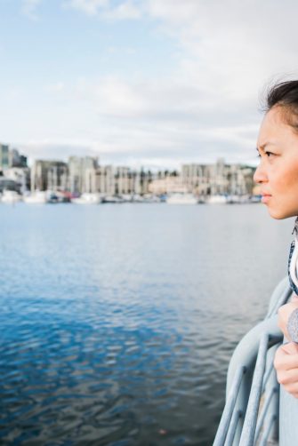 Young woman leaning against barrier, taking in view, Yaletown Ferrydock, Vancouver, Canada