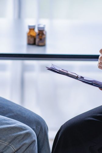 Woman with abdominal pain visiting doctor about stomach cancer symptoms, irritable bowel syndrome, discomfort woman menstrual pain concept