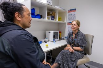 A doctor speaking to a patient in a room.