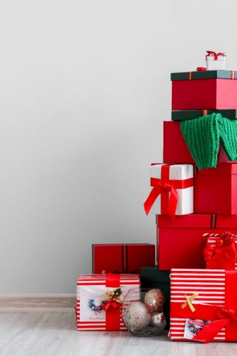 Beautiful Christmas gifts near light wall