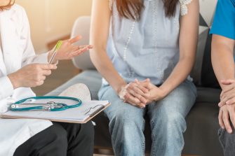Patient couple consulting with doctor or psychologist on marriage counseling, family medical healthcare therapy, In vitro fertility IVF treatment for infertility, or psychotherapy session concept
