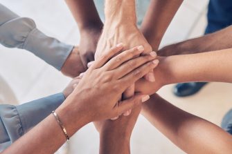 Teamwork, hands together and team building of business people with support, collaboration or startup mission for company background. Hand stack sign, community and solidarity group in diversity above