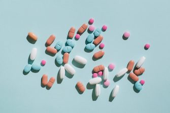 Colourful pills and capsules on a blue background