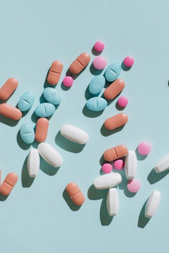 A pregnant woman taking a pill while sitting on her lounge at home