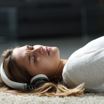Sad woman listening to music on the floor