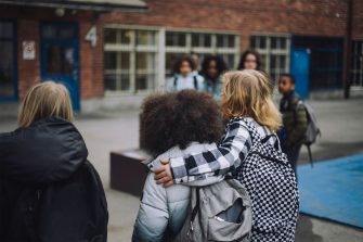 Primary students walk arm in arm to school