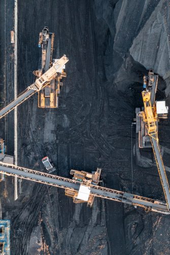 Territory of the coal terminal with coal dumps and a regenerator. loading and unloading of coal by excavators and belt conveyors. coal reserves at thermal power plants. View from above