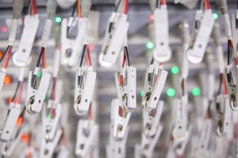 Professor Neeraj Sharma in his lab beside an array of batteries being charged